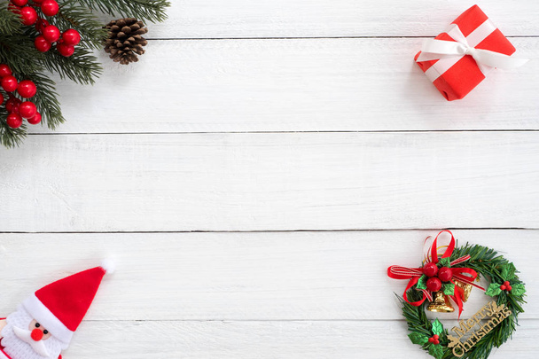 クリスマスの背景。モミの枝、ホリー ベリー ホワイト木製ボードに装飾が付いている赤いギフト ボックスといったクリスマス フレーム。創造的なフラットを産むが、平面図の設計. - 写真・画像