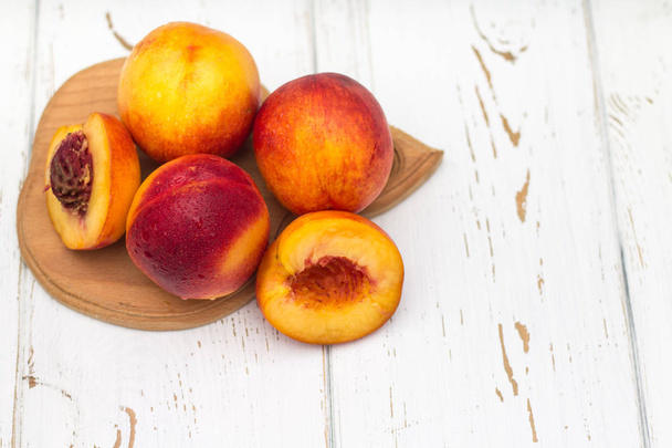 a lot of fresh peaches on a white table. - Valokuva, kuva