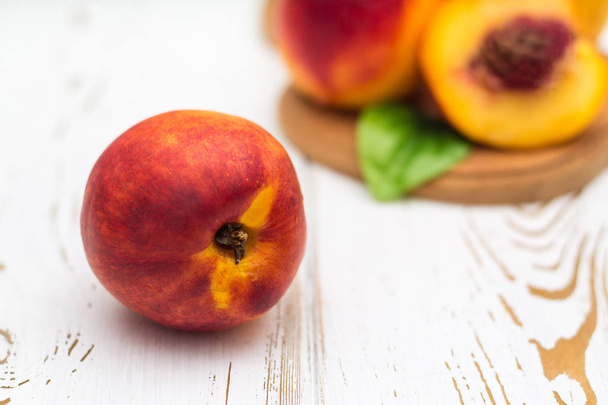 a lot of fresh peaches on a white table. - 写真・画像