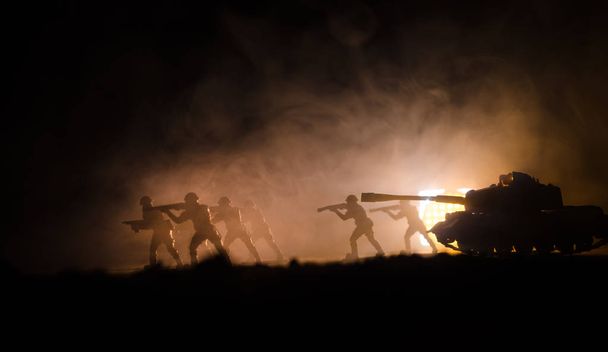 暗い霧の空の背景の兵士の軍のシルエット。爆発と戦う兵士の後ろに燃える雲との戦闘シーン。おもちゃ装飾 - 写真・画像