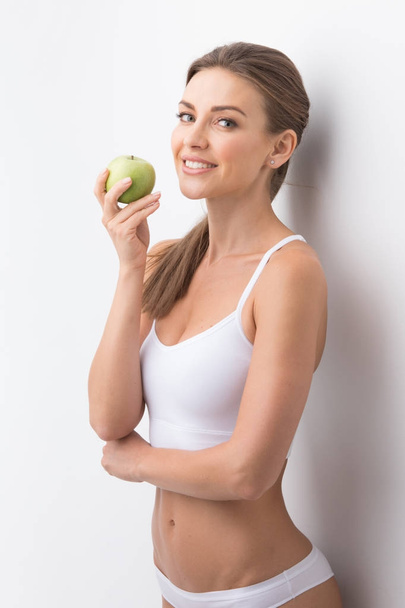 Sporty woman with apple - Foto, afbeelding