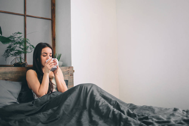 Good morning Woman woke up in bed. Woman drinking coffee in bed - Fotoğraf, Görsel