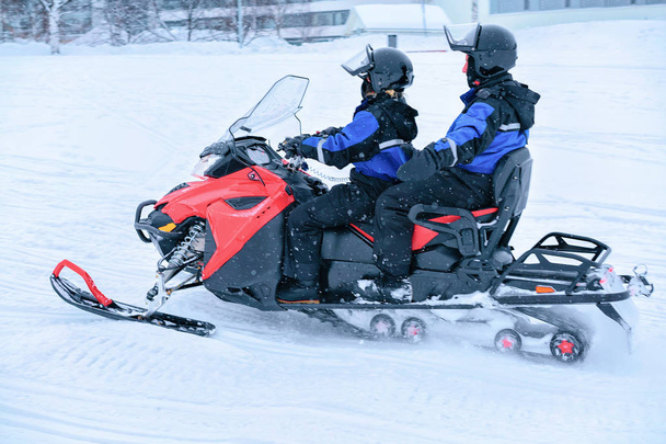 People ride snowmobile in frozen snow lake in winter Rovaniemi - Photo, Image