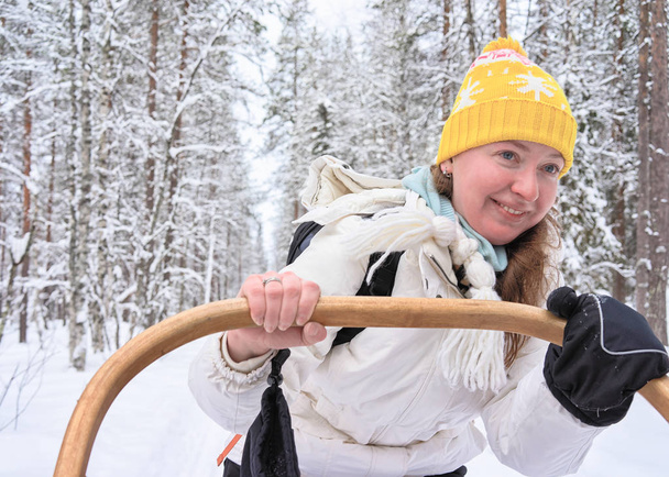 Woman riding in husky dogs sledge in Rovaniemi forest - Photo, Image