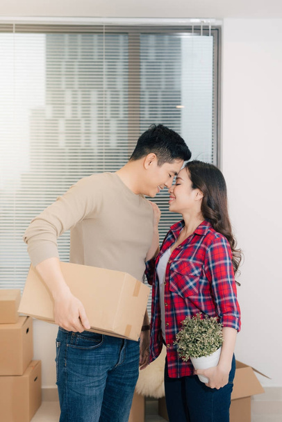 Happy young couple moving into new apartment with packaging boxes - Фото, изображение