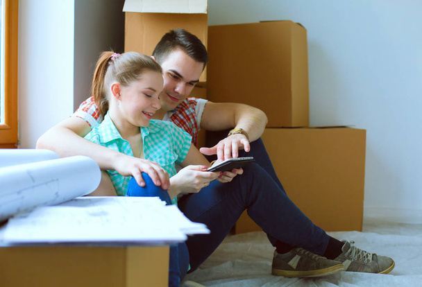 Couple moving in house sitting on the floor with ipad. Couple - Photo, Image