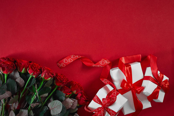Bovenaanzicht vers rood roze bloem en cadeau vak op rood dek met lege ruimte voor design. Voor liefde of valentijn dag concept - Foto, afbeelding