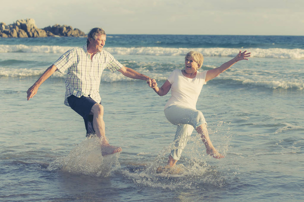 krásná starší zralý pár na jejich 60s nebo 70 let v důchodu chůzi šťastná a uvolněná na pláži mořského pobřeží v romantické stárnutí spolu  - Fotografie, Obrázek