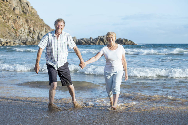 śliczny starszy Starsza para na ich 60s i 70s emeryturę, spacer szczęśliwy i zrelaksowany na brzegu morza plaży w romantycznej starzenia się razem  - Zdjęcie, obraz