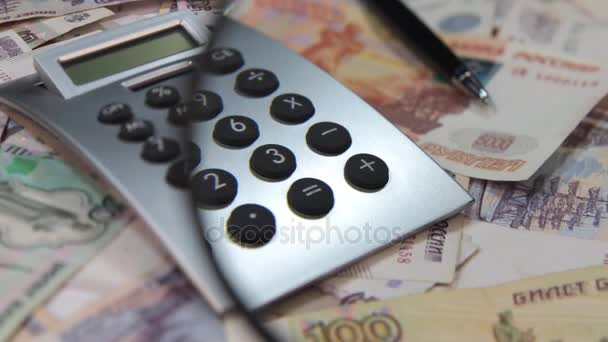 Rotation of rubles, calculator and pen through a magnifying glass. - Felvétel, videó