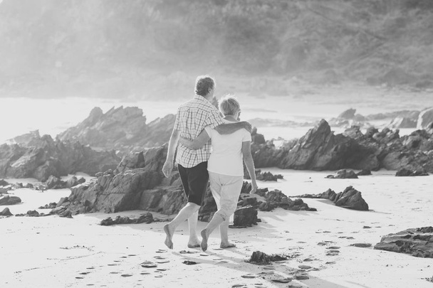 encantador casal maduro sênior em seus 60 ou 70 anos aposentado andando feliz e relaxado na praia costa do mar em envelhecimento romântico juntos
  - Foto, Imagem