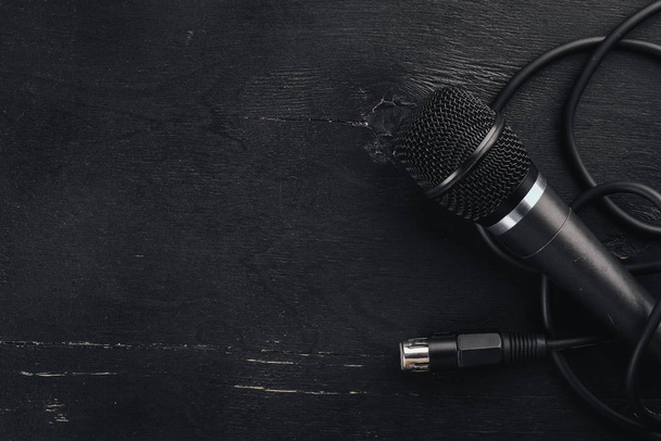Microphone on a wooden black table. Studio. Top view. Free space for text. Copy space. - 写真・画像