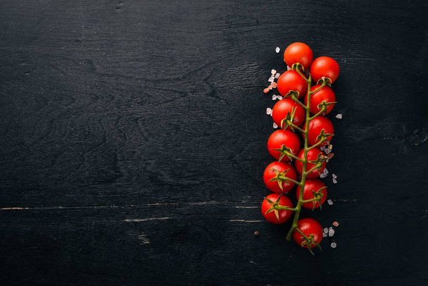 Cherry tomatoes on a twig on a wooden background. Top view. - Foto, Imagem