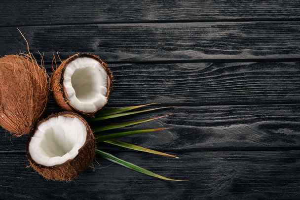 Coconut on a wooden background. Tropical fruits and nuts. Top view. Free space for text. - Fotografie, Obrázek