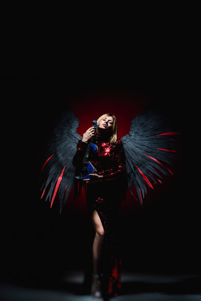 Žena s velkým andělskými křídly na černém pozadí. - Fotografie, Obrázek