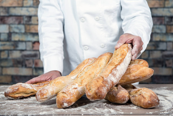 panadero con pan tradicional baguettes francesas
 - Foto, Imagen