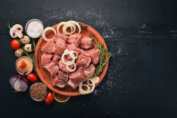 Raw meat is cooked for shish kebab on a wooden background. On the plate Top view. Free space for text. - Foto, Imagen