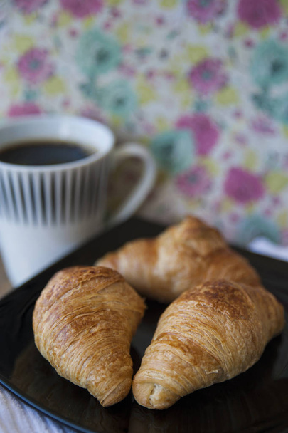 Breakfast with three croissants and large black coffee in an old-fashioned style setup, with copy space and selective focus - Photo, Image