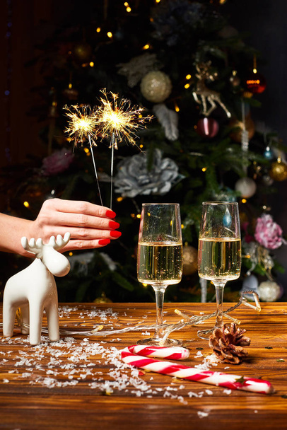 Decoraciones de venados de juguete navideño en la mesa con champán
 - Foto, Imagen