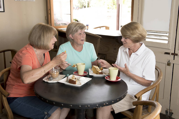 Grupa trzech przyjaciółek starszy dojrzałe kobiety piękne średnim wieku spotkanie na kawę i herbatę z ciasta w coffee shop dzielenie czasu razem - Zdjęcie, obraz