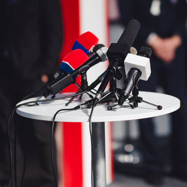 Conferência de imprensa, microfones em uma mesa
 - Foto, Imagem