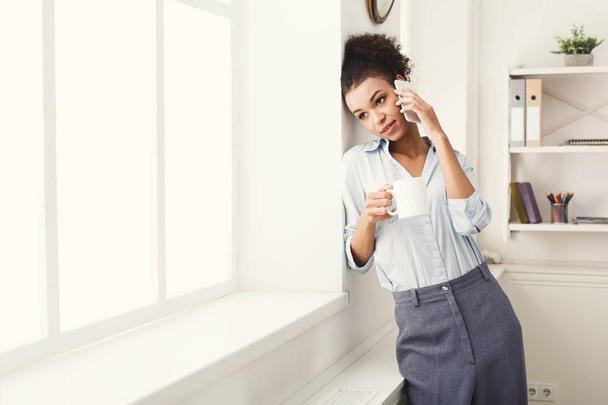Business woman has phone talk near office window - Foto, Imagen