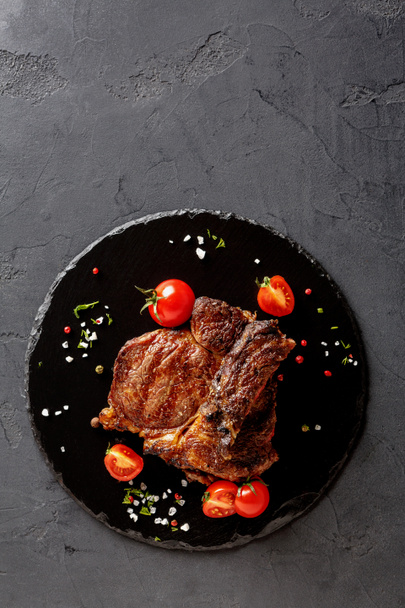 Rare rib eye steak on dark plate, top view - Fotoğraf, Görsel