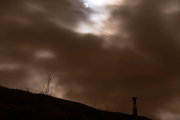 Hombre silueta mirando super luna a través de prismáticos
 - Foto, imagen