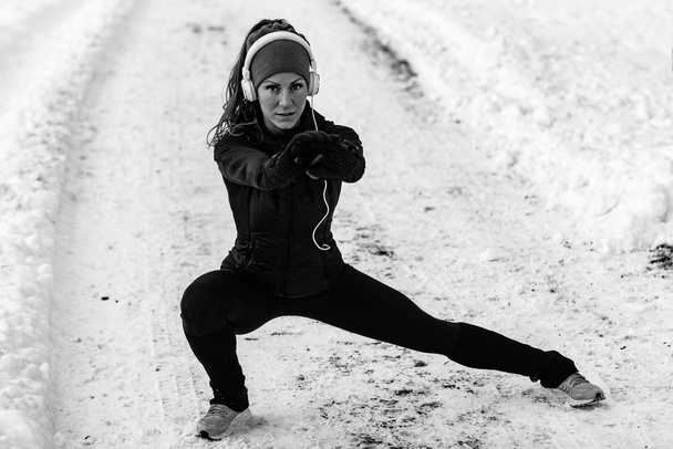 Női sportoló gyakorlása a park, a téli nap. Zene és gyakorlása - Fotó, kép