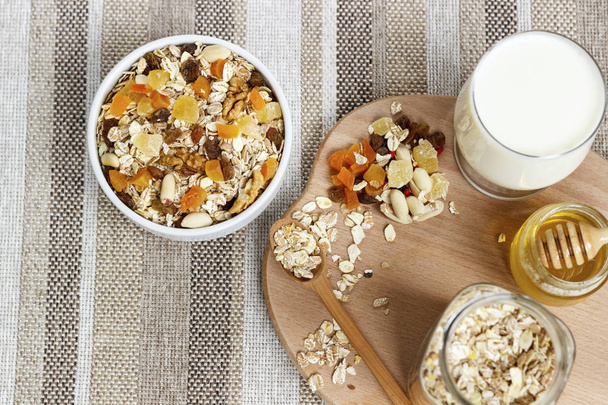 Healthy eating. On the wooden board are muesli, a spoon, a glass - Fotó, kép