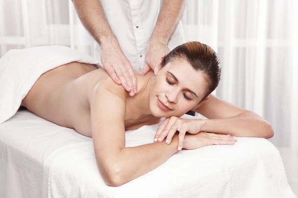 Professional masseur doing massage of female back in the beauty salon - Photo, Image
