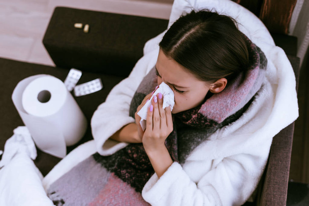 悲しい少女は冷たい冬の天候のために非常に病気になった彼女の首周りに暖かいスカーフくしゃみ - 写真・画像