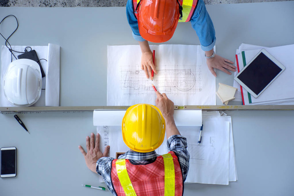 Top view of group of engineering team is meeting, planning construction work,looking paper plans at construction site,overhead view,Concept for team work - 写真・画像