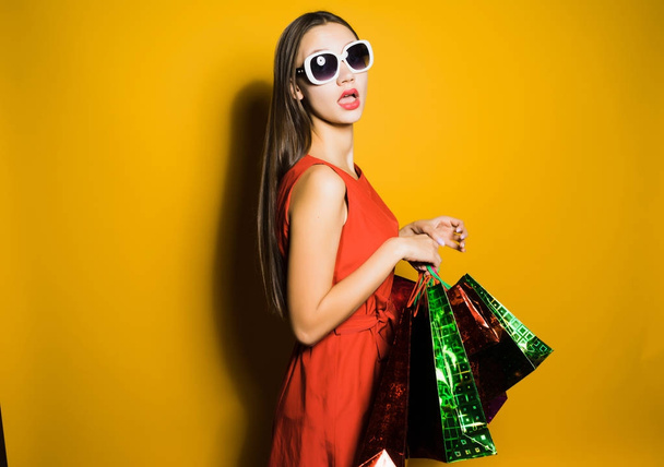 surprised young girl shopaholic in sunglasses waiting for big discounts - Zdjęcie, obraz
