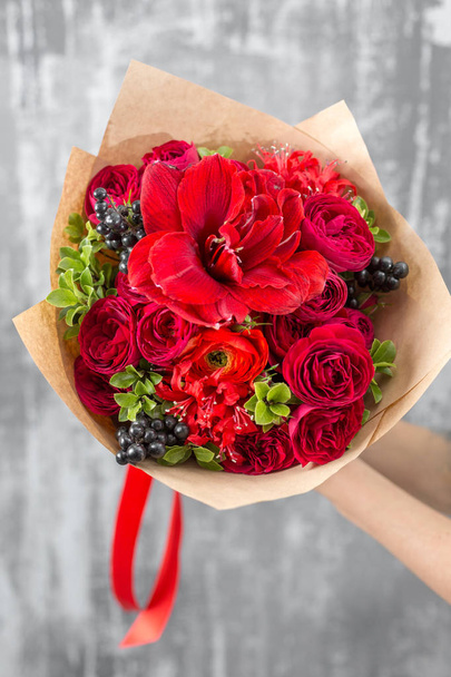 schöner luxuriöser Strauß gemischter Blumen in Frauenhand. die Arbeit des Blumenhändlers in einem Blumenladen. rote Farbe - Foto, Bild