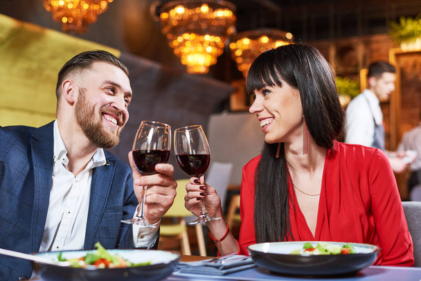 young man and woman celebrating in restaurant - Zdjęcie, obraz