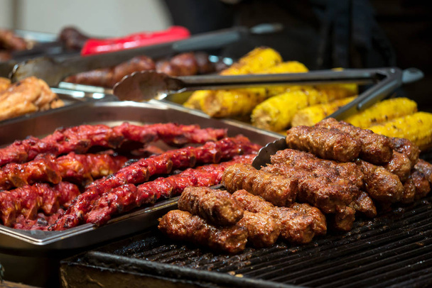 Traditional romanian food meat balls - mici, spare ribs and corn baked on grill - 写真・画像