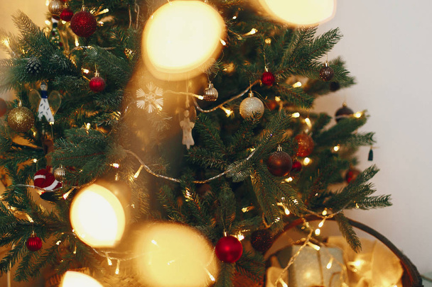 όμορφο κομψό χριστουγεννιάτικο δέντρο με φώτα γιρλάντα και χρυσά στολίδια - Φωτογραφία, εικόνα