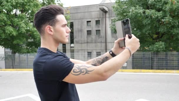 Νεαρός άνδρας λήψη selfie φωτογραφία έξω από - Πλάνα, βίντεο