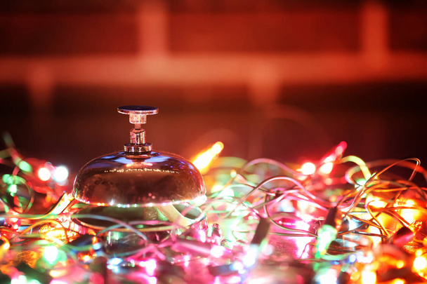 Recepce zvonek na stůl a barva svítící věnec na pozadí - Fotografie, Obrázek