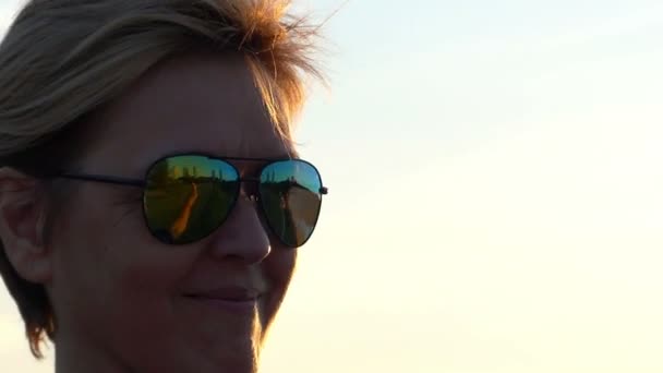 Uśmiechający się kobieta w okulary przeciwsłoneczne pokazuje dwa kciuk gesty - Materiał filmowy, wideo