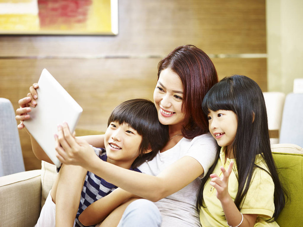 Aziatische moeder en twee kinderen nemen een selfie met behulp van digitale tabl - Foto, afbeelding