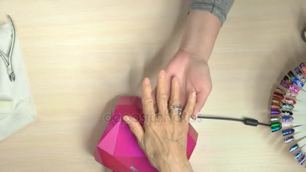 Senior woman receiving manicure in nail salon. - Footage, Video