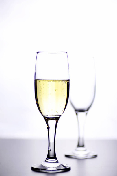 склянка білого вина на столі на білому фоні ізольовані
 - Фото, зображення