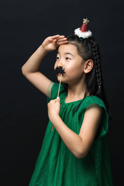 偽の口ひげとクリスマス ヘッド装飾黒の背景上でアジアの女性のかわいい子 - 写真・画像