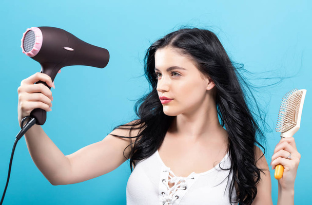 Beautiful woman holding a hairdryer - Photo, image