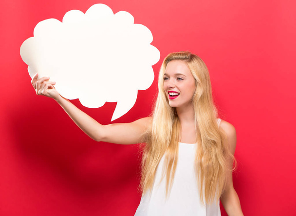 Young woman holding a speech bubble - Foto, afbeelding