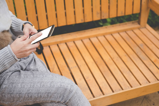 donna utilizzare smartphone in giardino. ragazza seduta sulla panchina nel parco. p
 - Foto, immagini