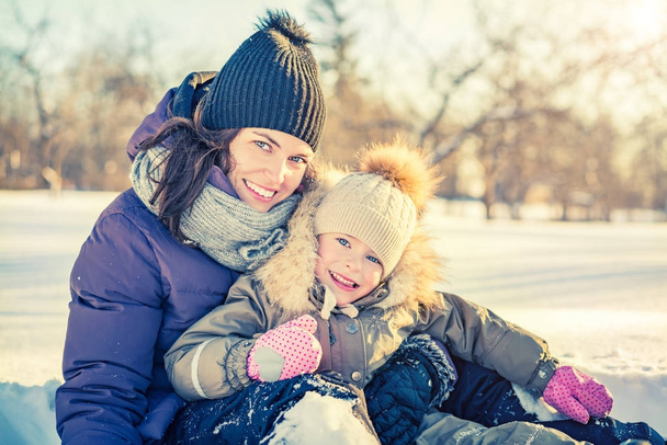 Mother and daughter playing at winter day - Photo, Image