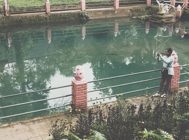 woman take photo of green tranquil pond in park. people, travel  - Φωτογραφία, εικόνα